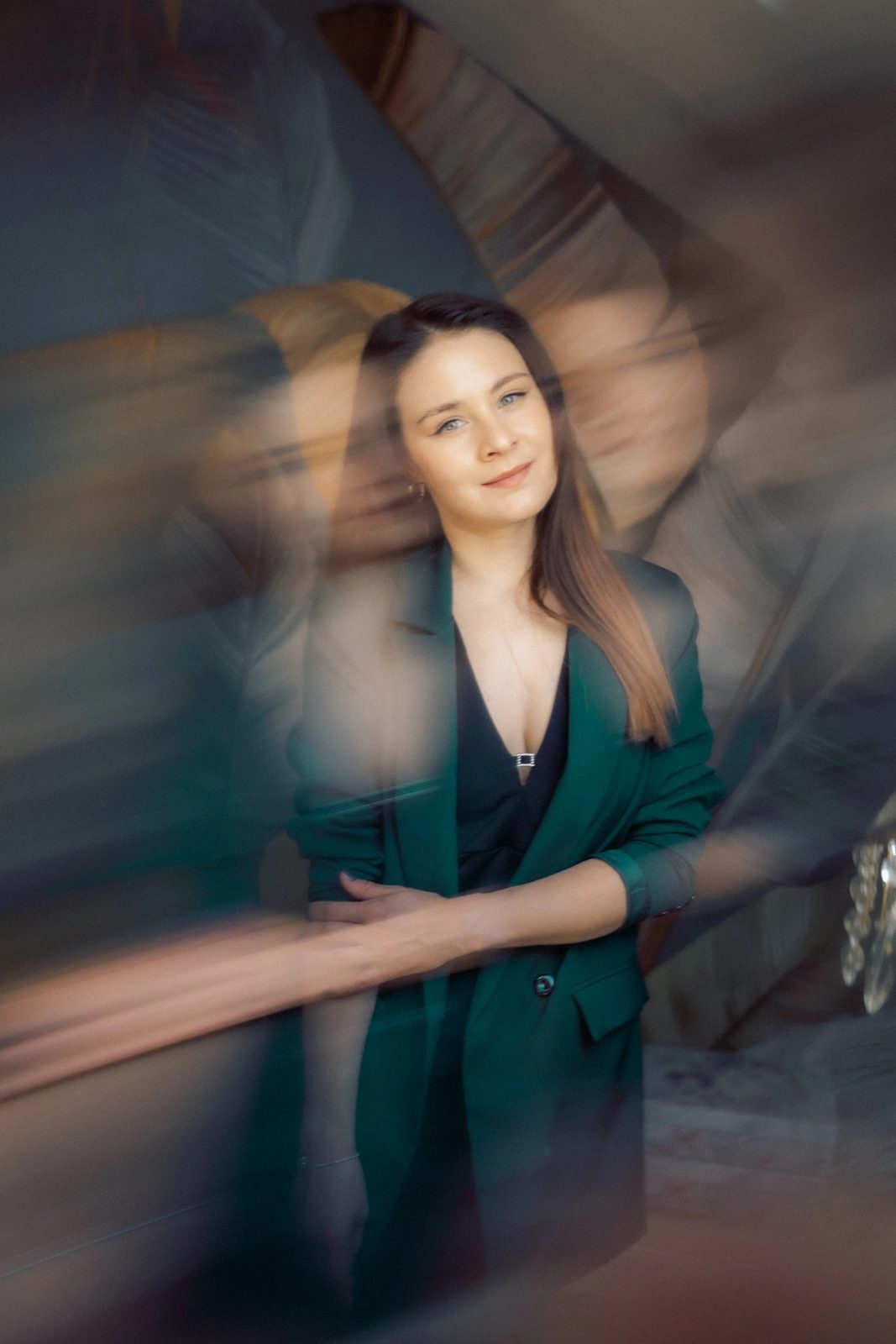 Woman in an emerald blazer framed by swirling motion