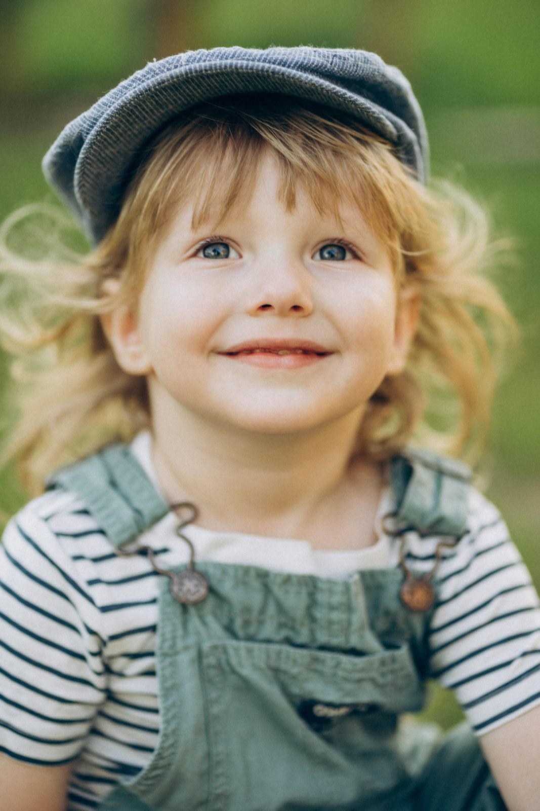 Smiling little boy in a cap and striped tee