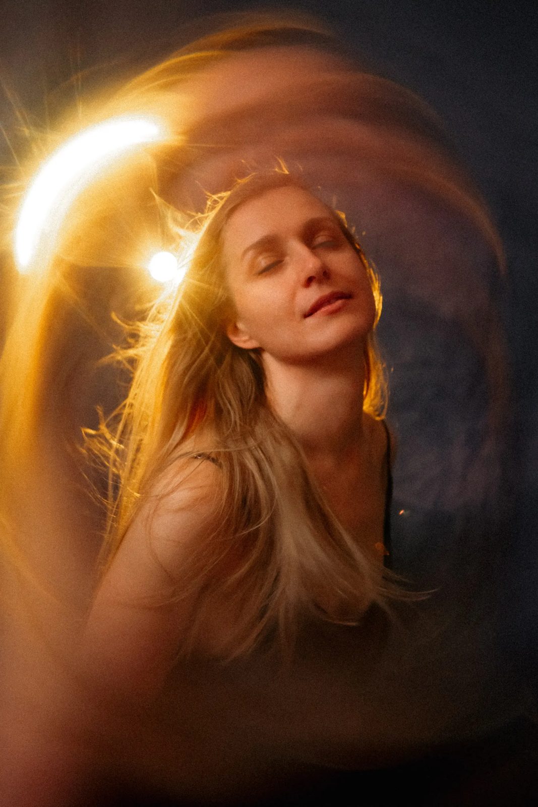 Woman with closed eyes inside a ring of golden light