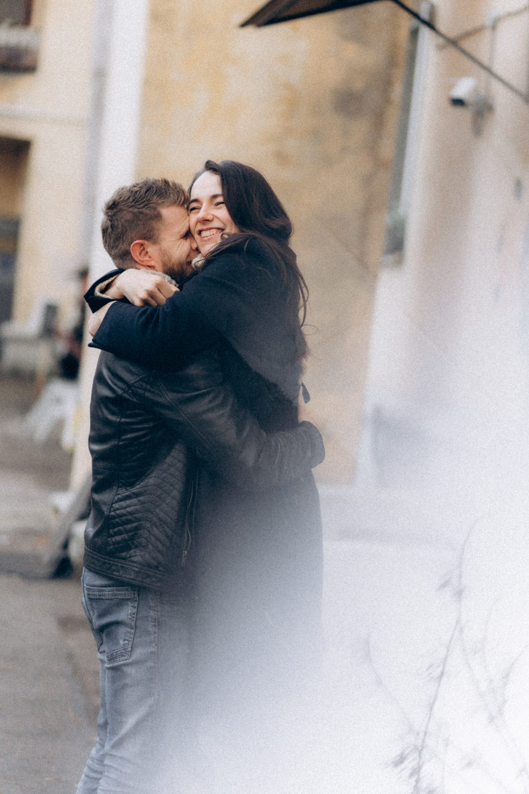 Couple hugging and laughing in an old courtyard