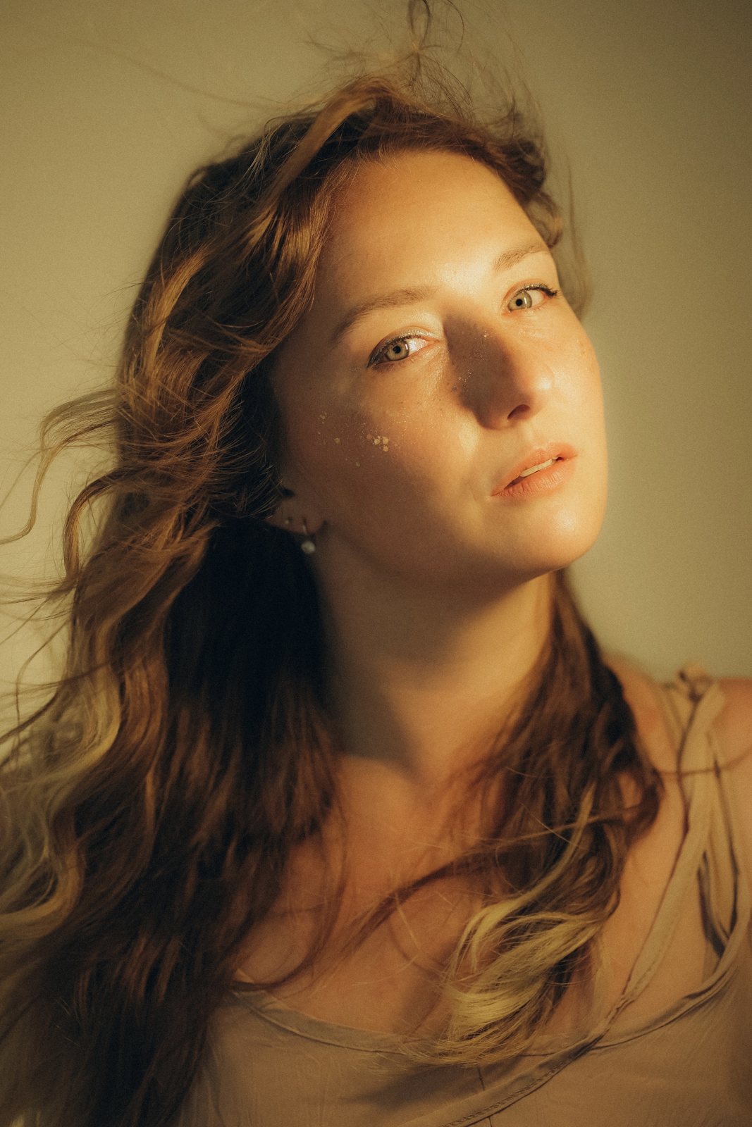 Portrait of Marie Perry with windswept auburn hair in warm golden light