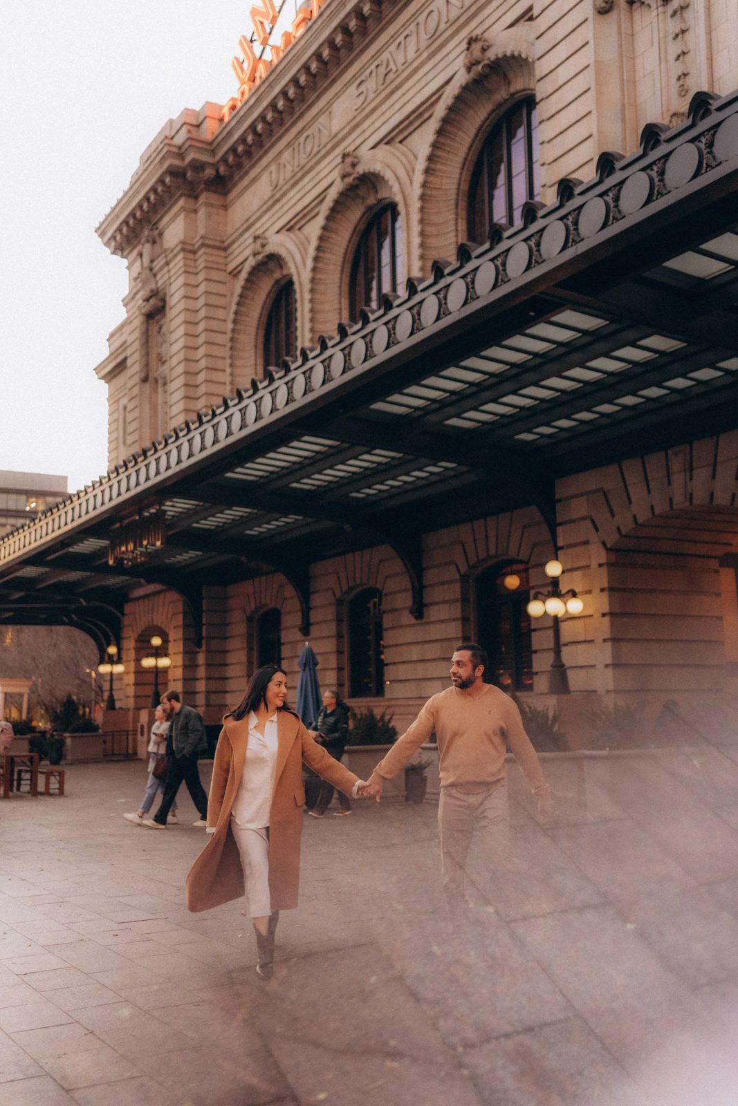 Couple walking hand in hand past Union Station in Denver